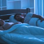 couple sleeping with moonlight glow on them
