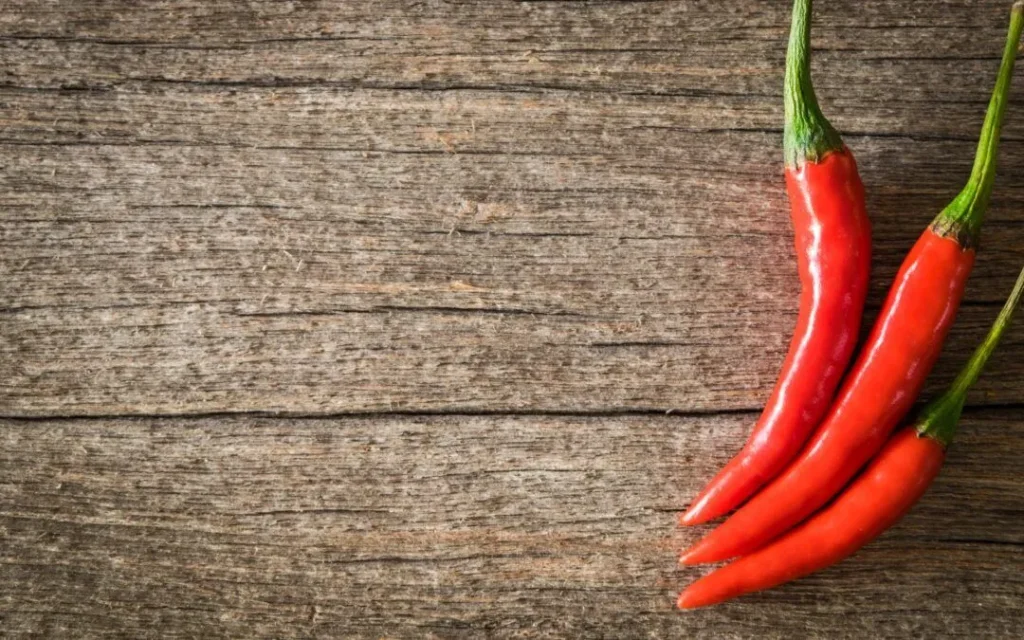 Red chili peppers on a rustic wooden surface
