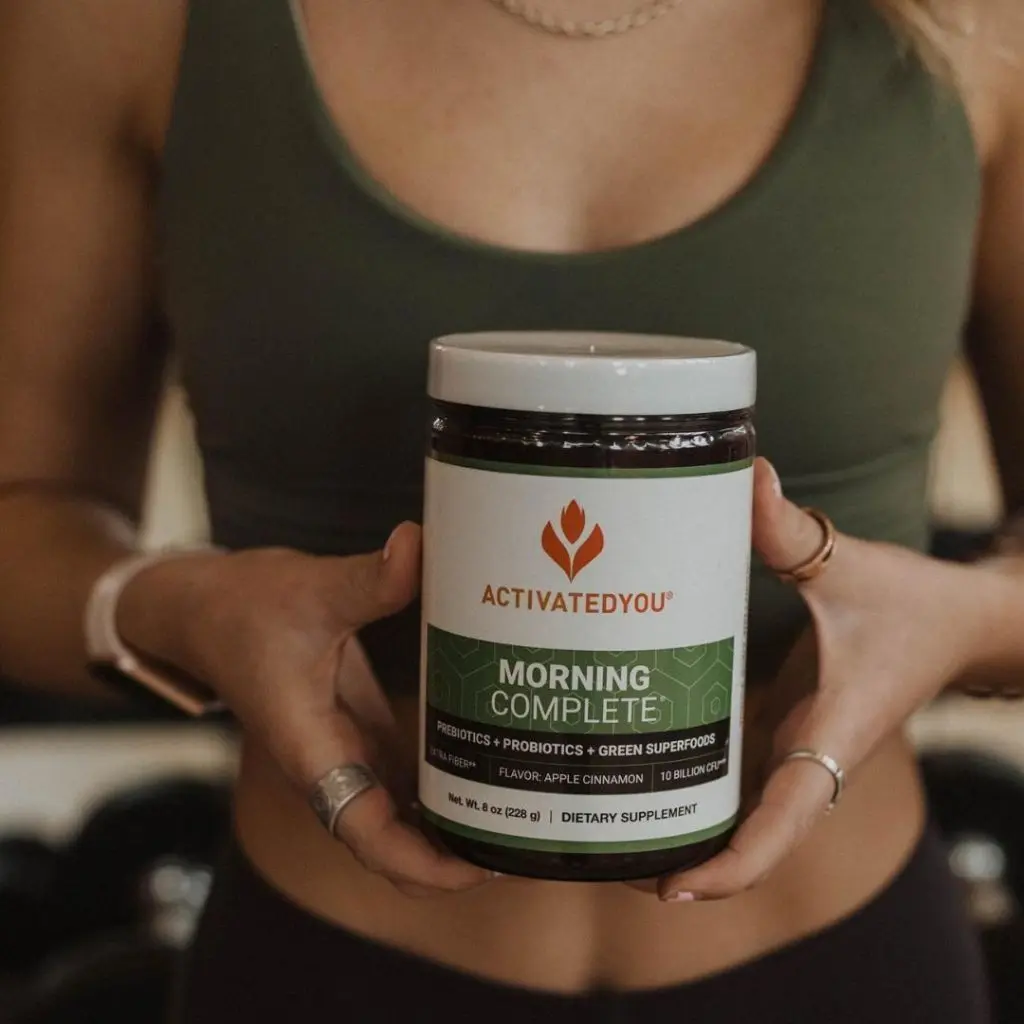A woman holding a jar of Morning Complete Apple Cinnamon