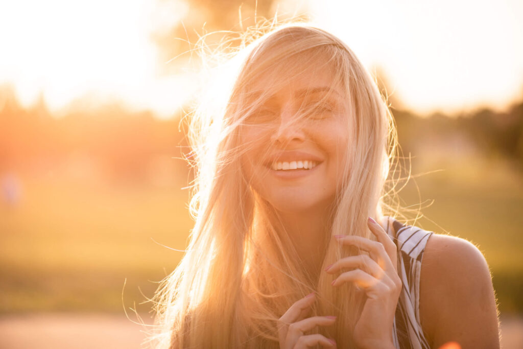 a happy, healthy woman glows in a sunset
